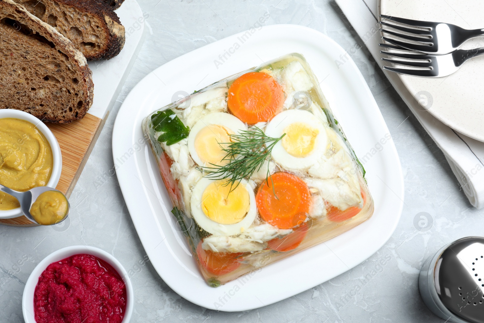 Photo of Delicious fish aspic served on grey marble table, flat lay