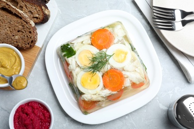 Photo of Delicious fish aspic served on grey marble table, flat lay