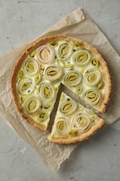 Photo of Tasty leek pie on grey textured table, top view