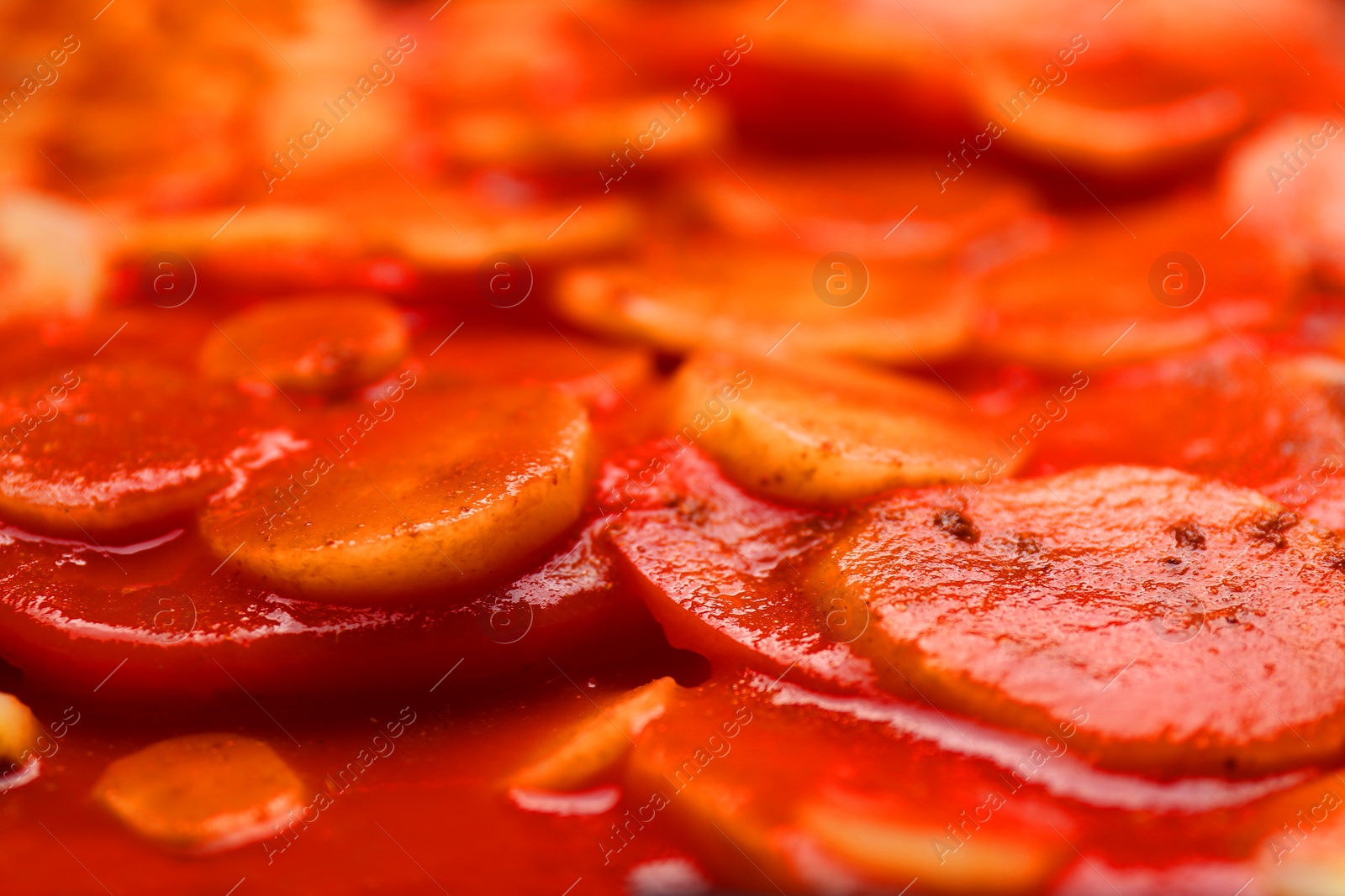 Photo of Tasty baked parsnips with red sauce, closeup