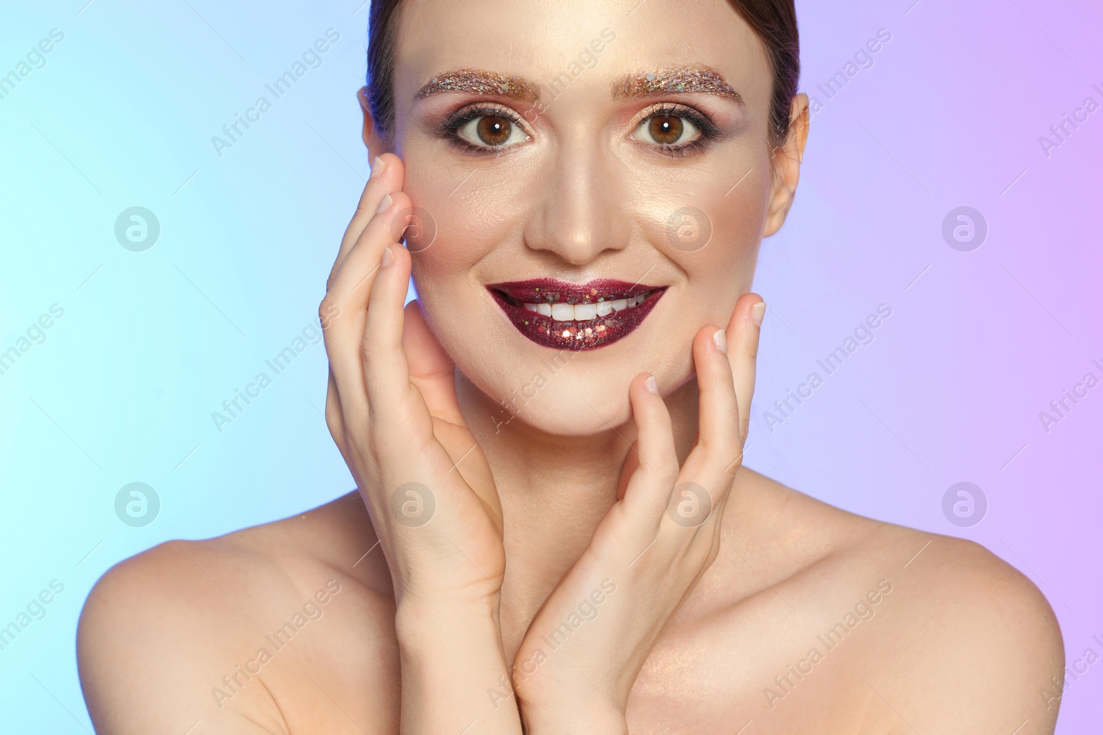 Photo of Beautiful young woman with glitter makeup on colorful background