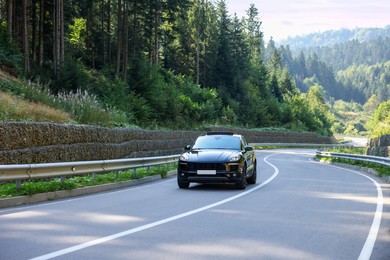 Picturesque view of asphalt road with modern black car outdoors