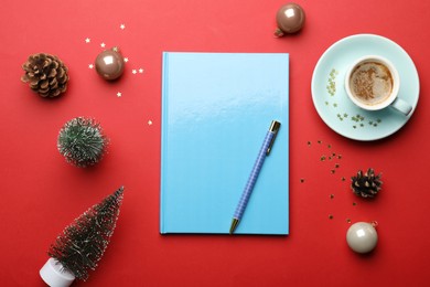 Light blue planner, cup of coffee and Christmas decor on red background, flat lay