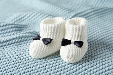 Handmade baby booties on soft knitted plaid