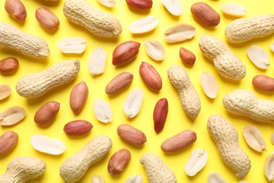 Fresh peanuts on yellow background, flat lay