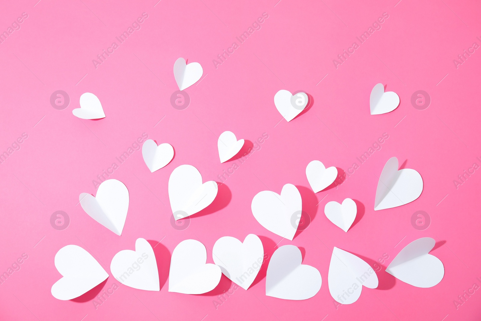 Photo of Small paper hearts on color background, top view