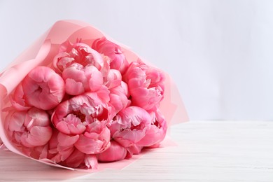 Photo of Bouquet of beautiful pink peonies on white wooden table. Space for text