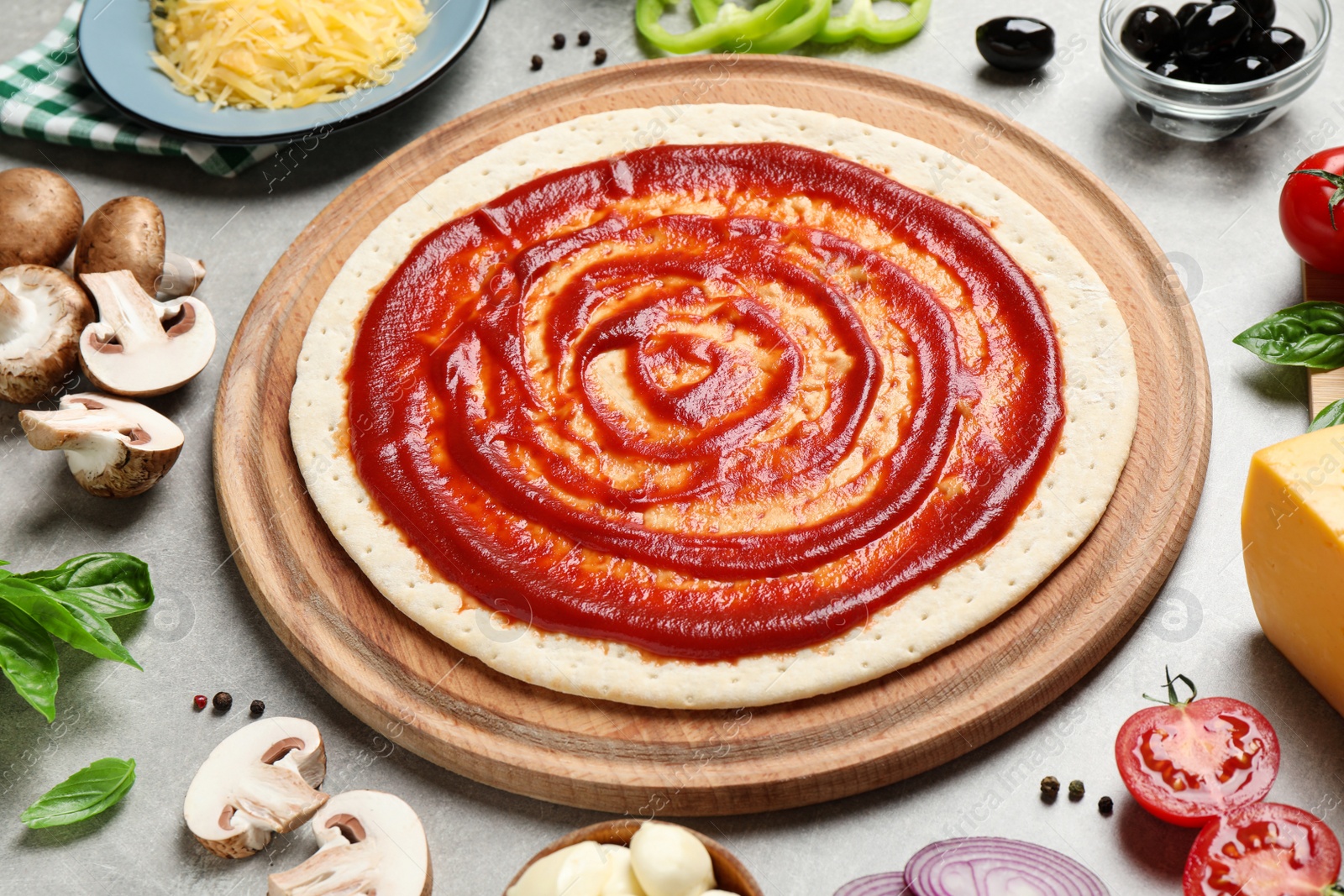 Photo of Composition with pizza crust and ingredients on grey table