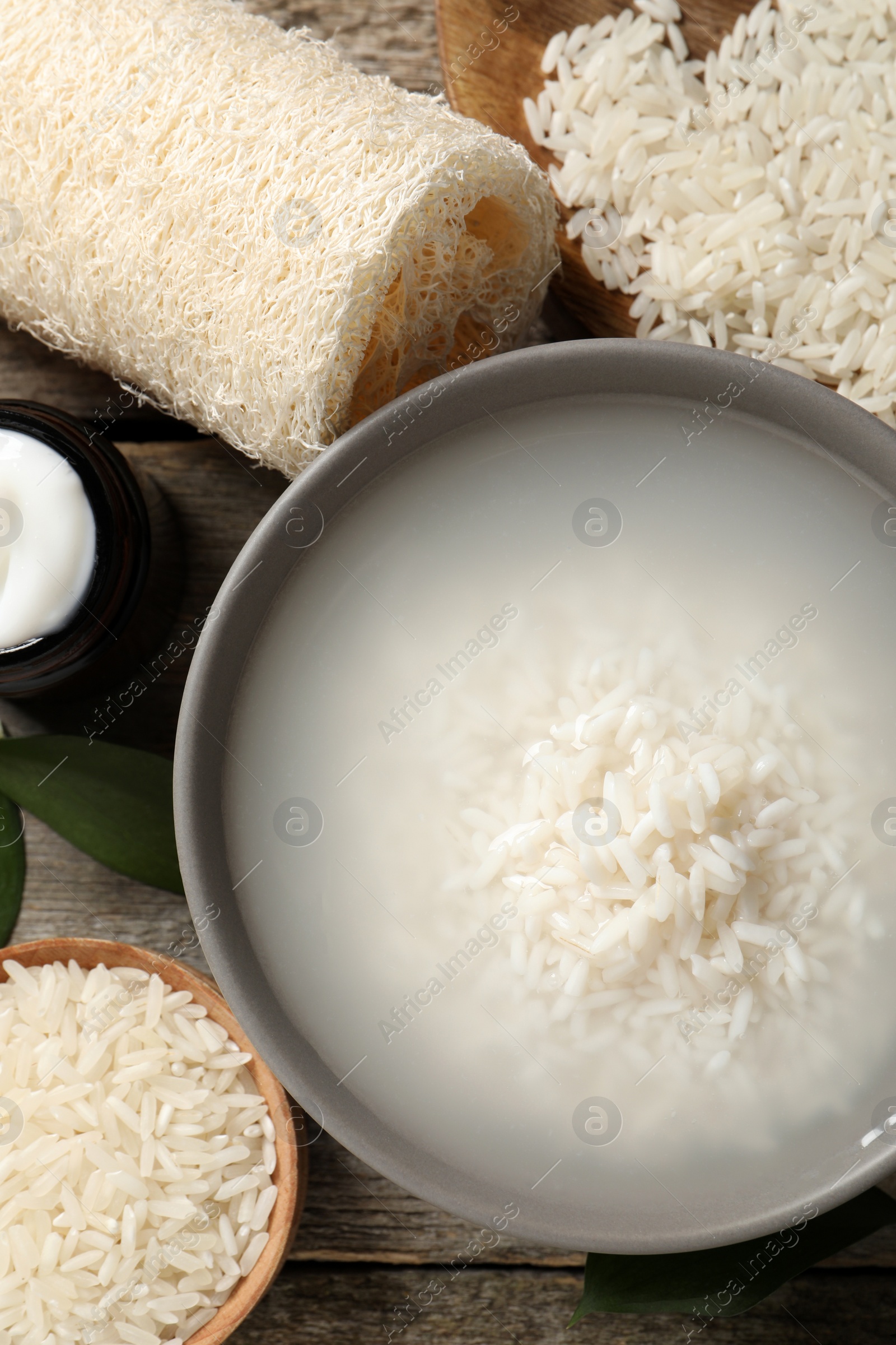 Photo of Flat lay composition with soaked rice on wooden table