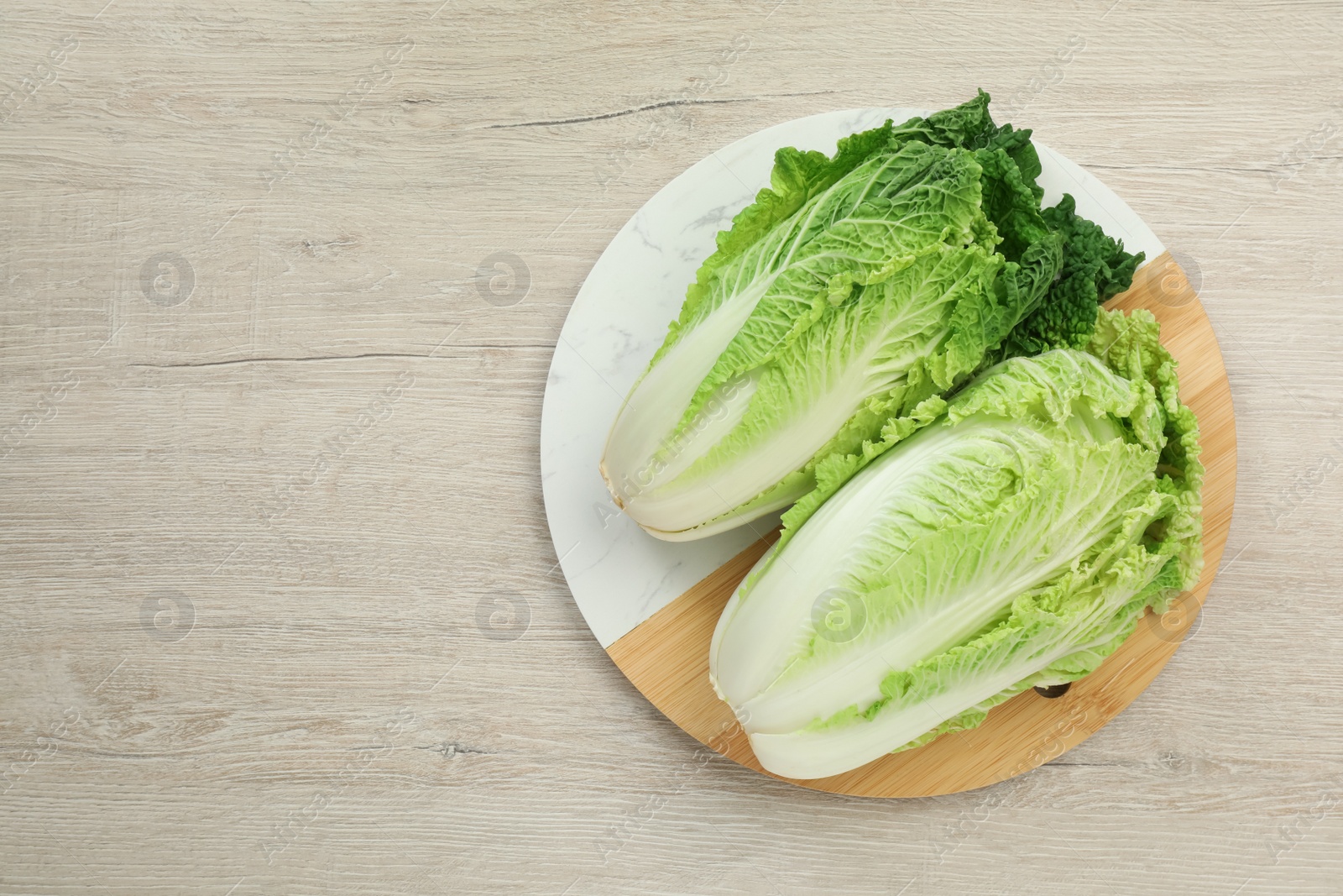 Photo of Fresh ripe Chinese cabbages on white wooden table, top view. Space for text