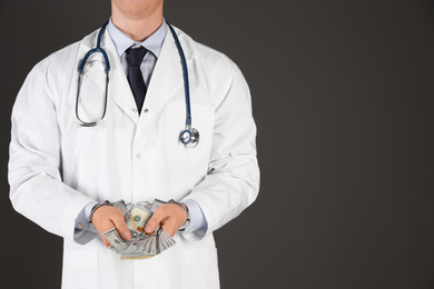 Photo of Doctor in handcuffs with bribe on black background, closeup. Corrupted medicine