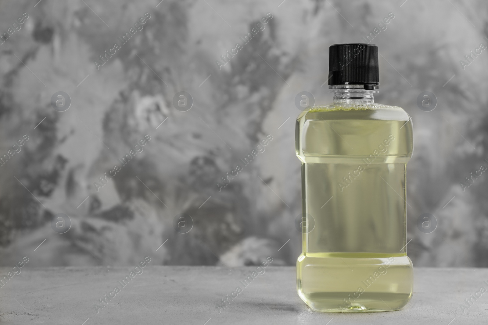 Photo of Mouthwash on grey table, space for text