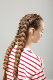 Woman with braided hair on grey background