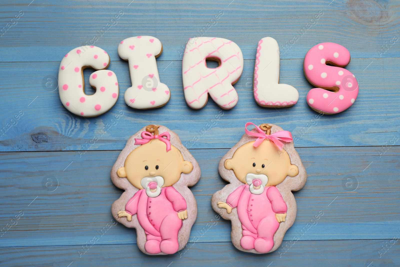 Photo of Word Girls made of tasty cookies on light blue wooden table, flat lay. Baby shower party