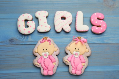 Photo of Word Girls made of tasty cookies on light blue wooden table, flat lay. Baby shower party