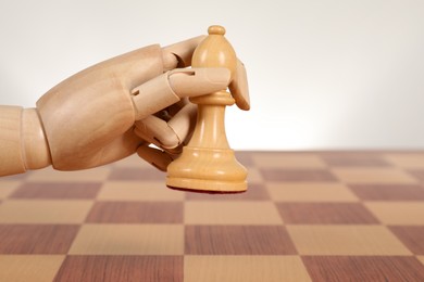 Robot with chess piece above board against light background, space for text. Wooden hand representing artificial intelligence