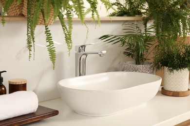 Photo of Counter with sink and many different houseplants near white marble wall