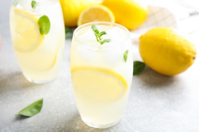 Photo of Glasses of cold lemonade on grey table, closeup