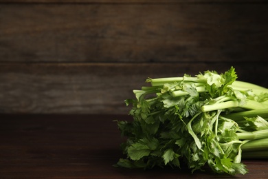 Fresh ripe green celery on wooden table. Space for text