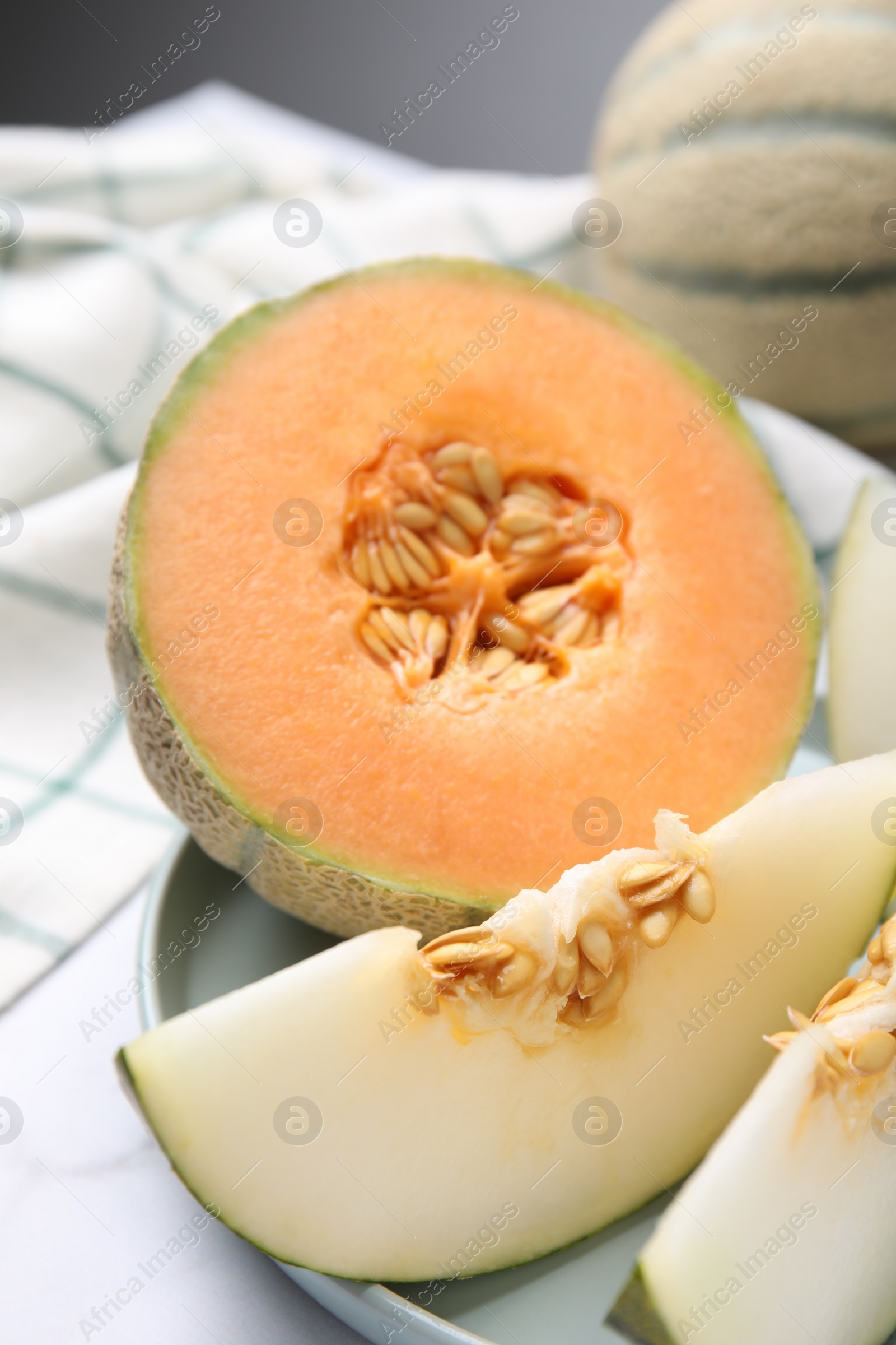 Photo of Tasty colorful ripe melons on white marble table, closeup