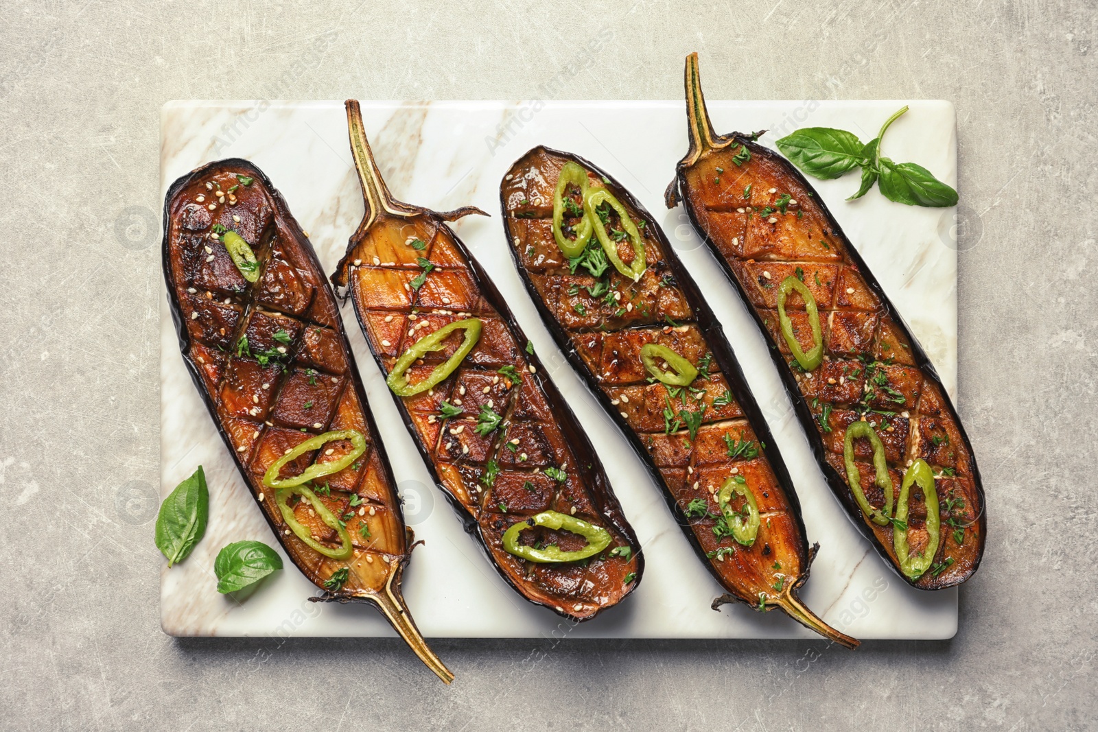 Photo of Board with fried eggplant slices on grey background, top view