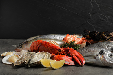 Photo of Fresh fish and different seafood on grey table