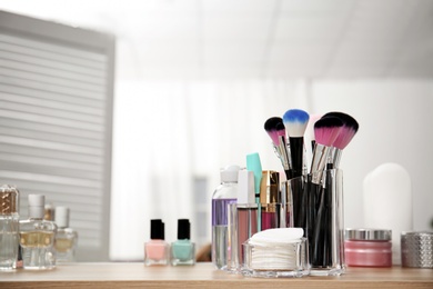 Photo of Organizer with makeup cosmetic products and space for text on dressing table