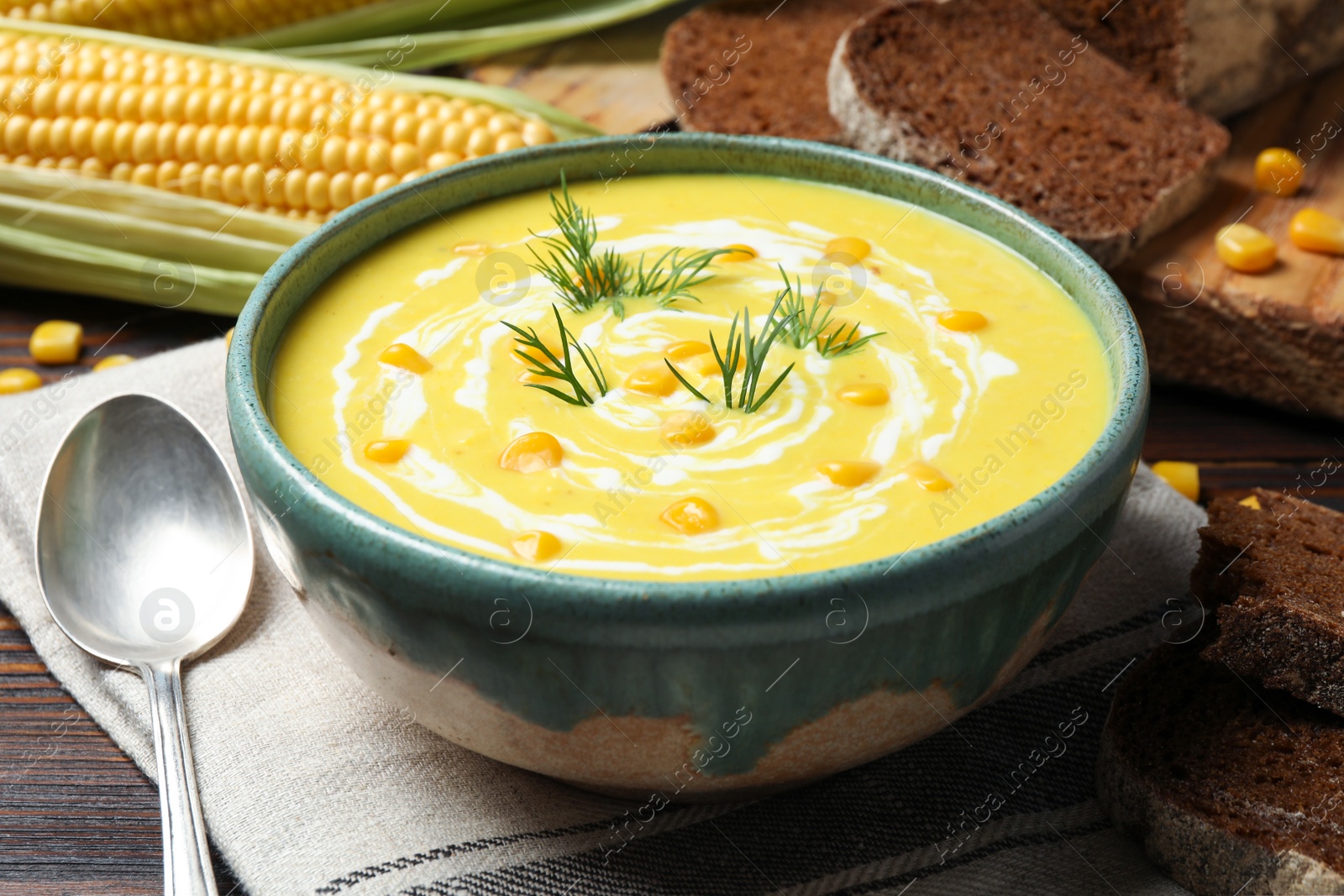 Photo of Delicious creamy corn soup served on wooden table