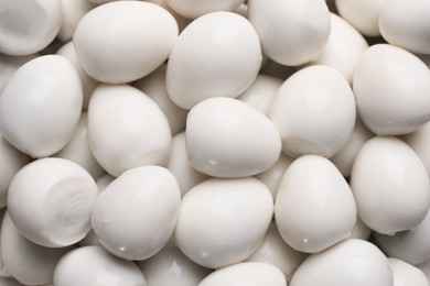 Photo of Peeled boiled quail eggs as background, top view