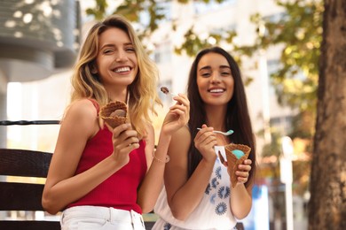 Photo of Young women with ice cream spending time together outdoors