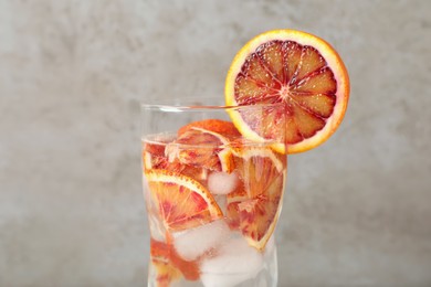 Photo of Delicious refreshing drink with sicilian orange on beige background, closeup