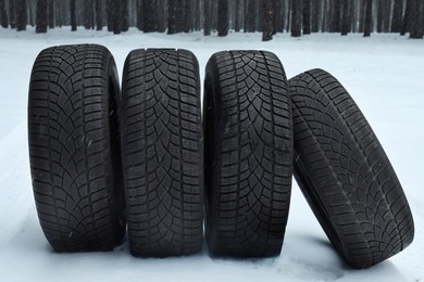 Photo of New winter tires on fresh snow near forest