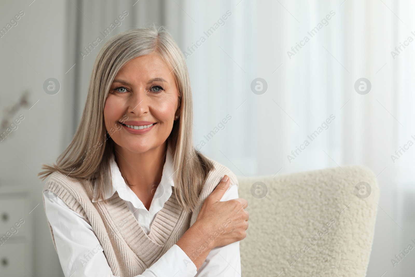 Photo of Portrait of beautiful middle aged woman at home, space for text