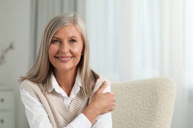 Photo of Portrait of beautiful middle aged woman at home, space for text
