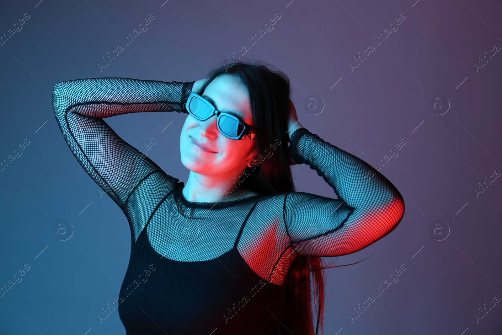 Photo of Portrait of beautiful young woman with sunglasses on color background