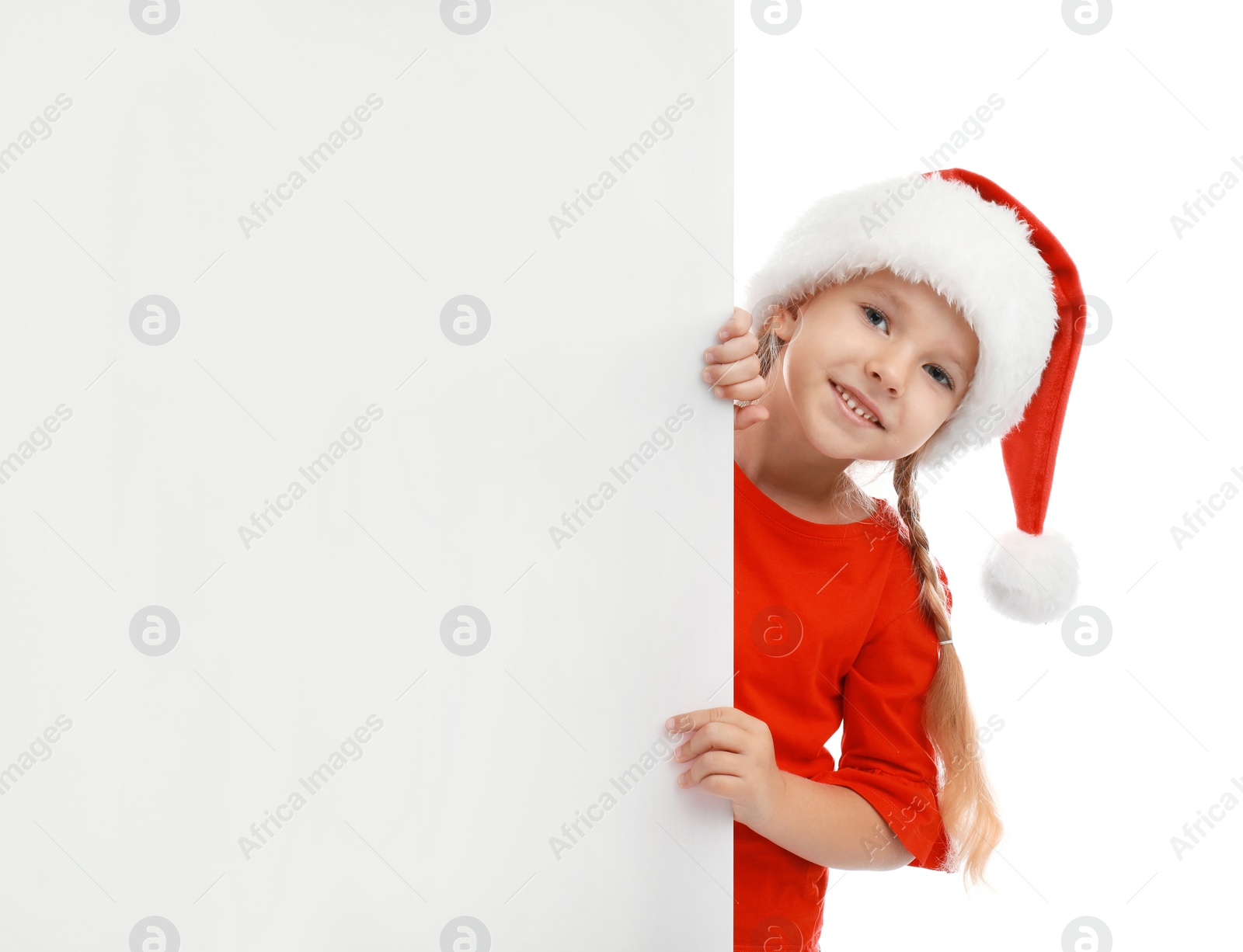 Photo of Cute little child wearing Santa hat on white background. Christmas holiday