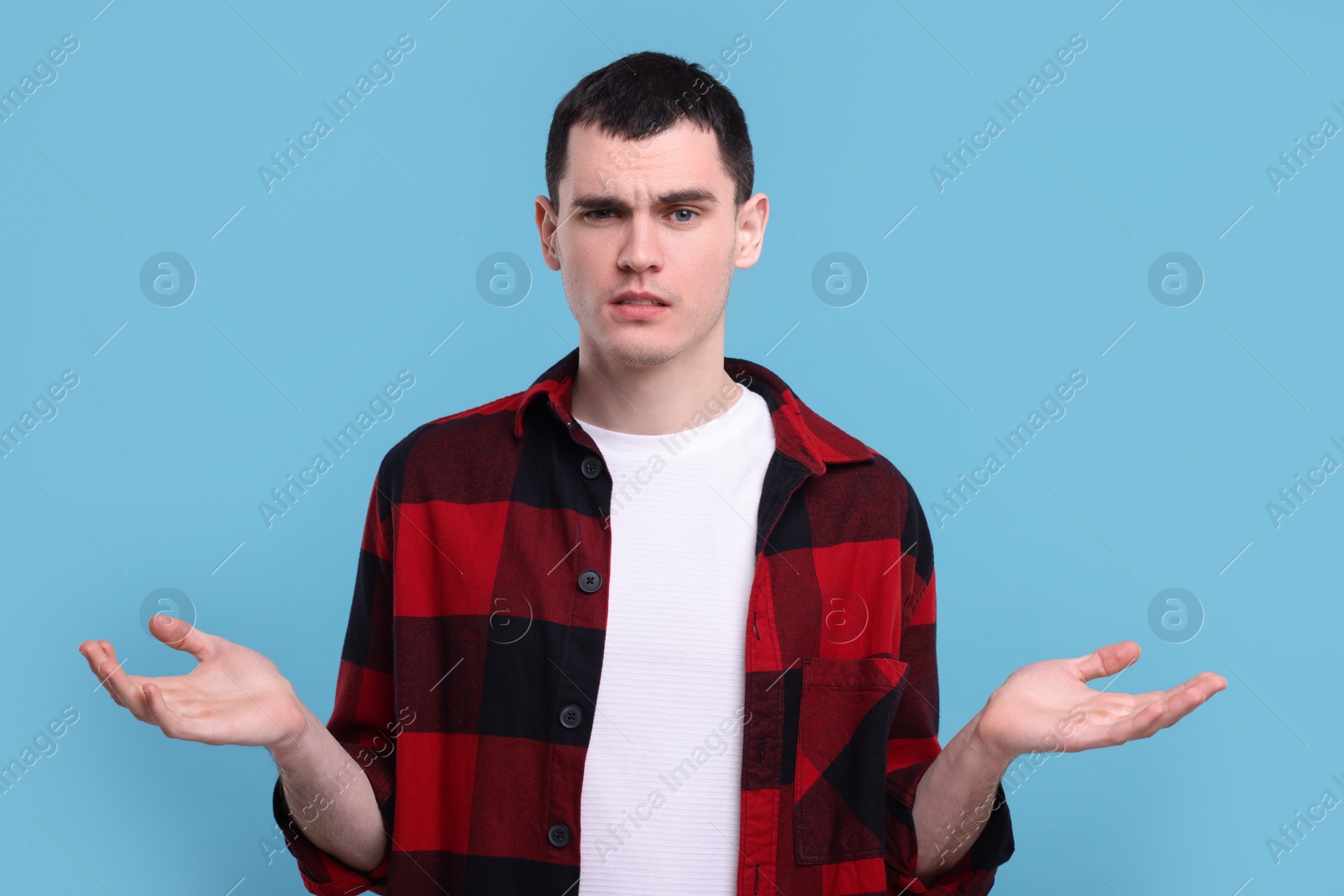 Photo of Portrait of surprised man on light blue background