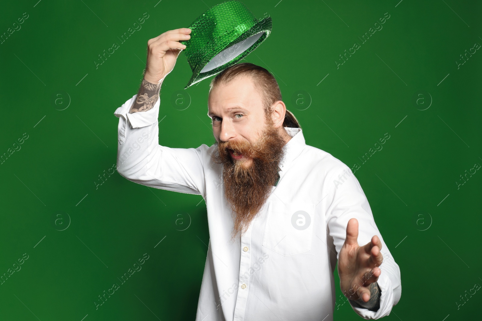 Photo of Bearded man with green hat on color background. St. Patrick's Day celebration