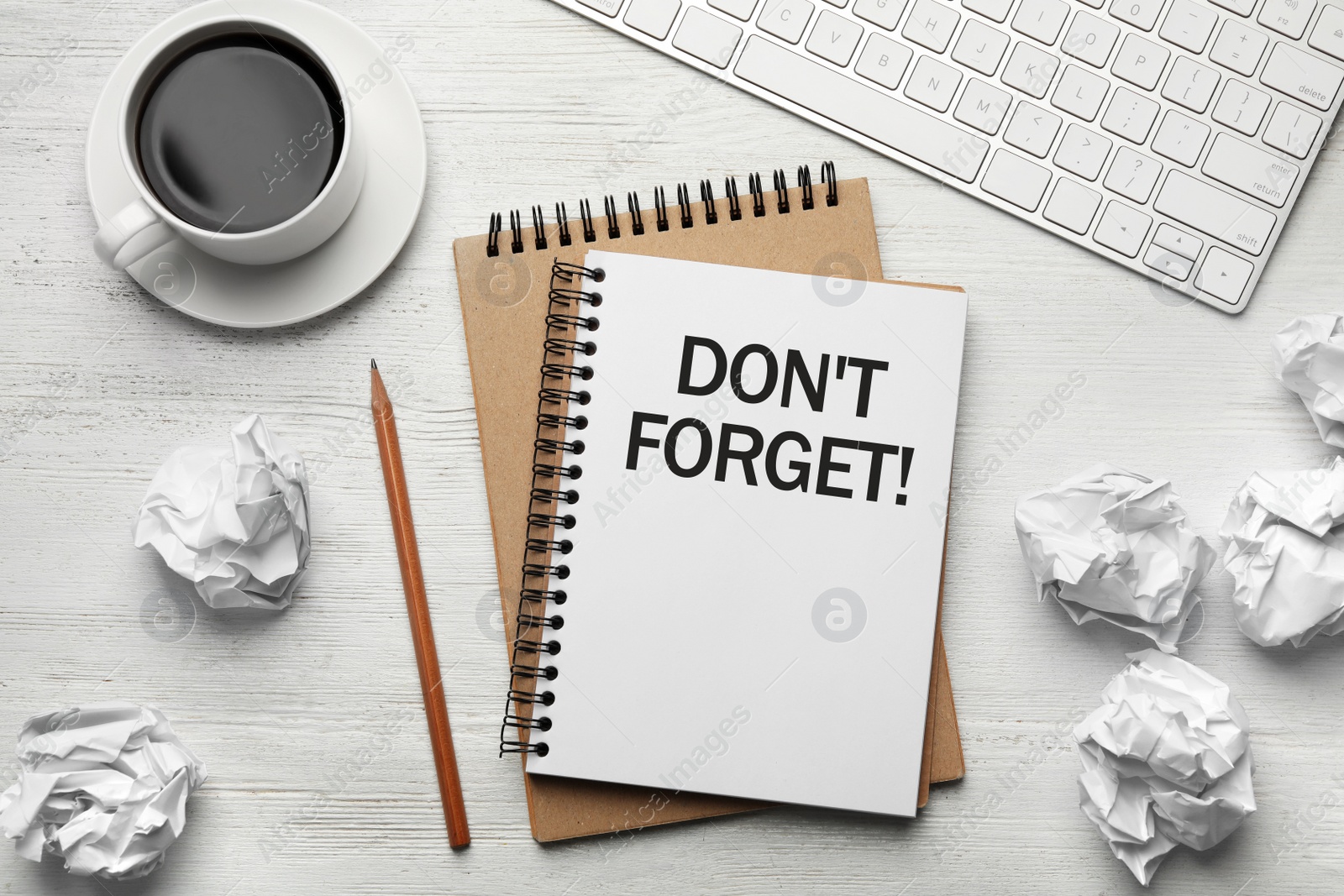 Image of Reminder DON'T FORGET written in notebook on wooden white table, flat lay 