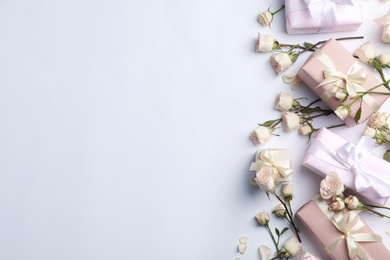 Photo of Flat lay composition with beautiful roses and gift boxes on white background. Space for text