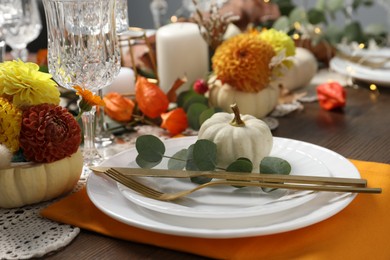 Beautiful autumn table setting. Plates, cutlery, glasses and floral decor, closeup
