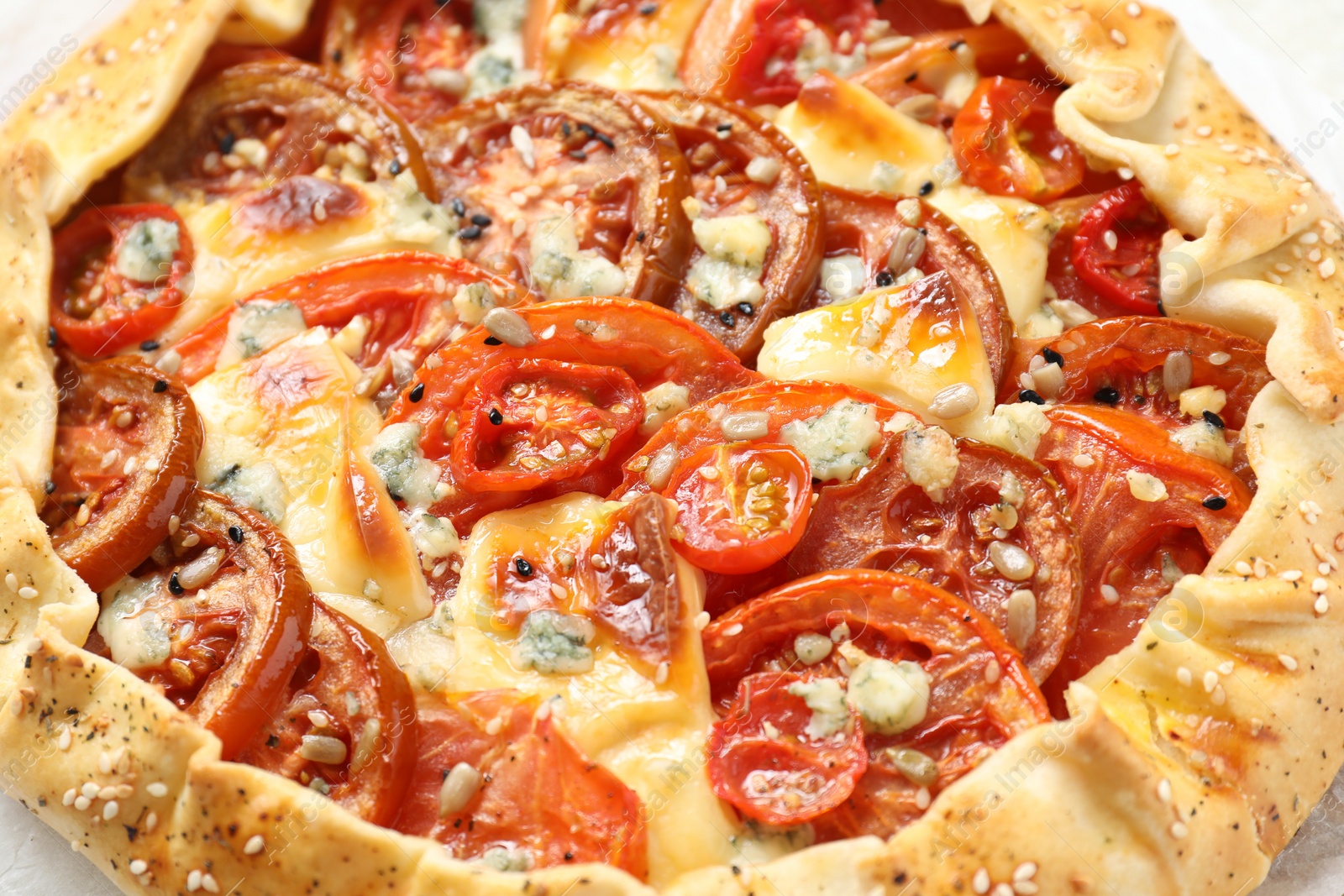 Photo of Tasty galette with tomato and cheese (Caprese galette) on table, closeup