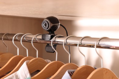 Photo of Camera hidden between hangers in wardrobe closet
