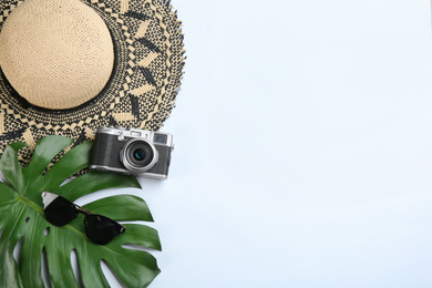 Camera for professional photographer and beach accessories on white background, top view