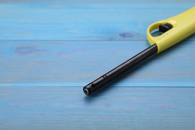 Photo of One gas lighter on light blue wooden table, space for text