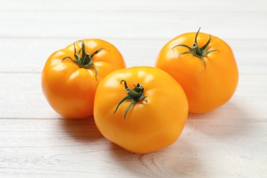 Photo of Fresh ripe yellow tomatoes on white wooden table