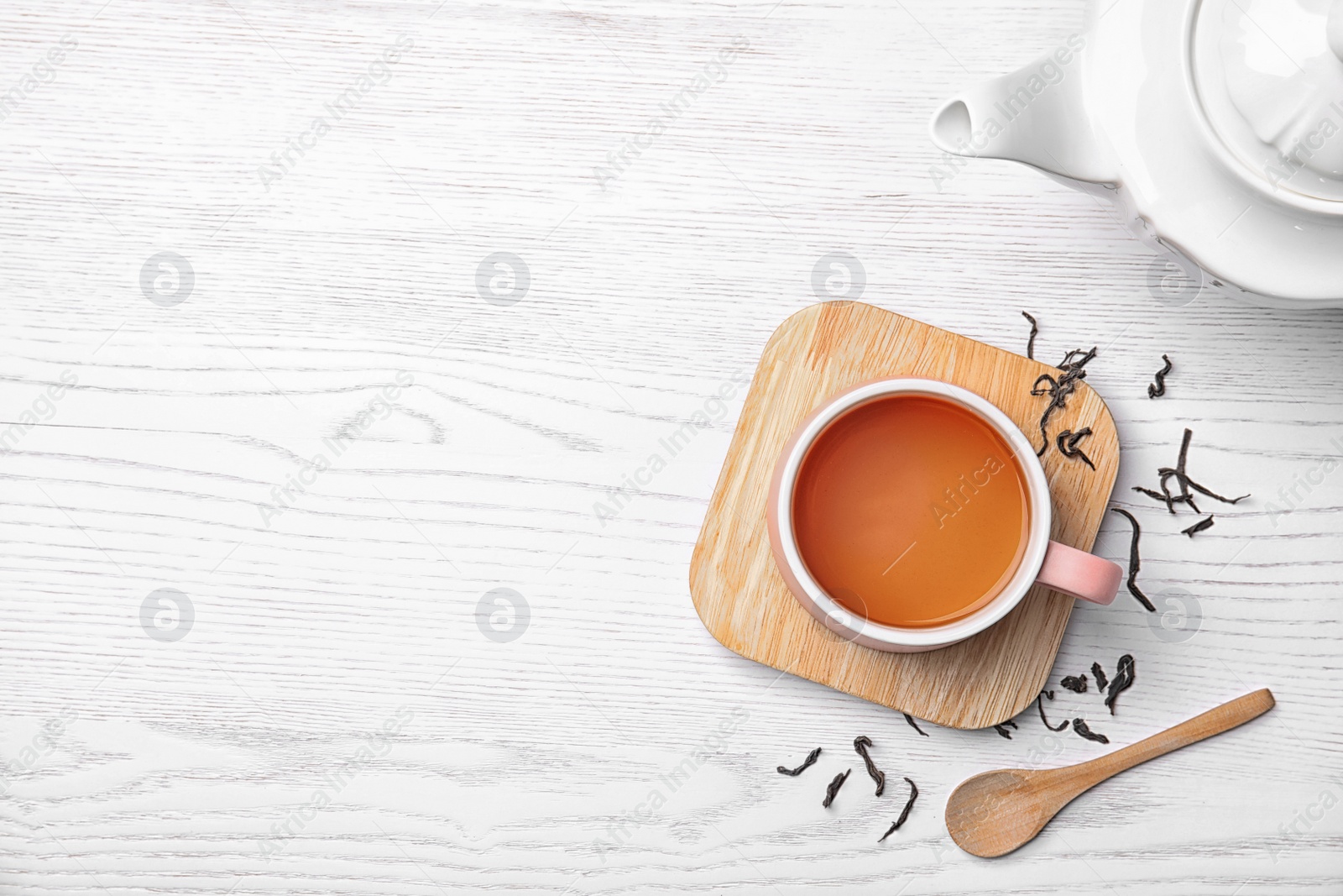 Photo of Cup of black tea on wooden table, top view