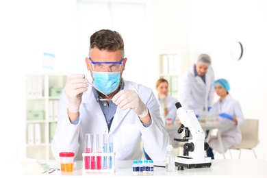 Photo of Male scientist working at table in laboratory, space for text. Research and analysis