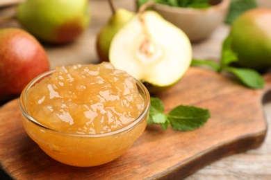 Delicious pear jam and fresh fruits on wooden board, closeup. Space for text