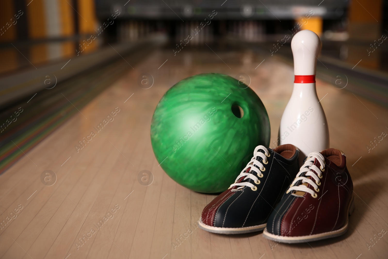 Photo of Pin, shoes and ball on alley in bowling club. Space for text